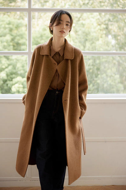 Woman wearing brown Flex-Weave long-staple cotton shirt layered under coat, showcasing versatile styling, relaxed fit, and polished look
