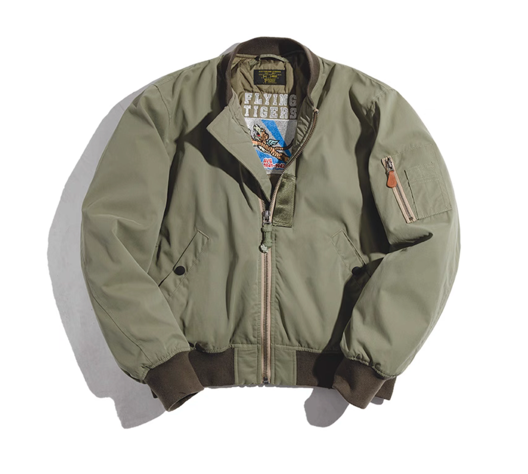 Army green MA-1 bomber jacket flat lay with Flying Tigers embroidered inner lining.