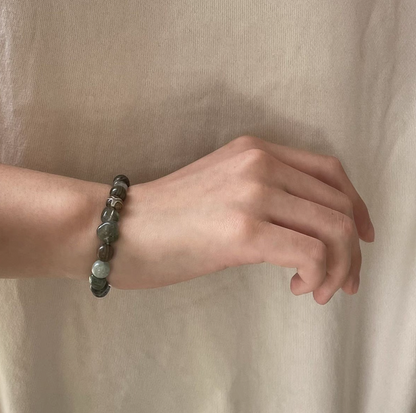 forest spirit gemstone bracelet in green rutilated quartz green serpentine and dzi beads worn on wrist