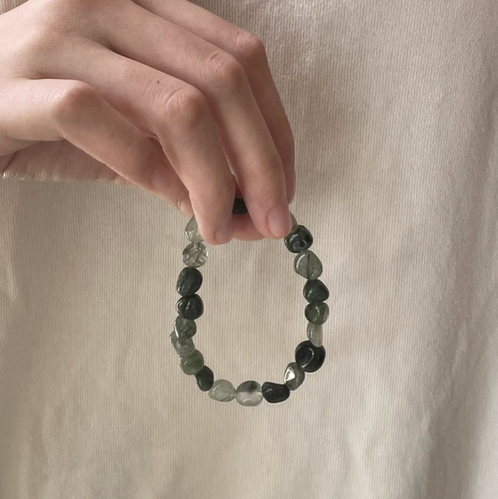 forest spirit gemstone bracelet in green rutilated quartz held in hand