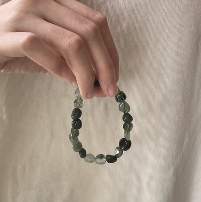 forest spirit gemstone bracelet in green rutilated quartz held in hand