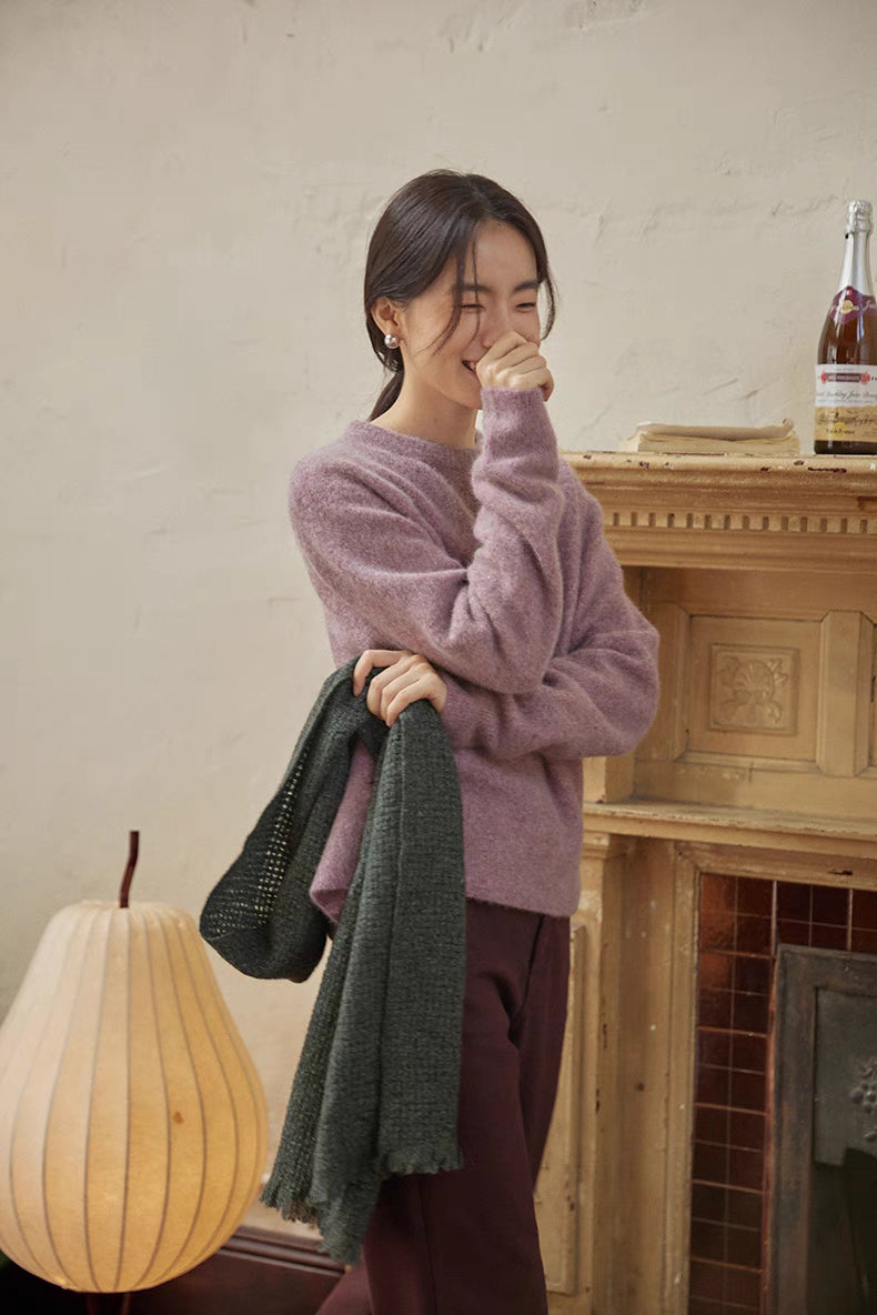 Cloud purple brushed wool sweater in lifestyle pose with warm interior lighting emphasizing softness and comfort
