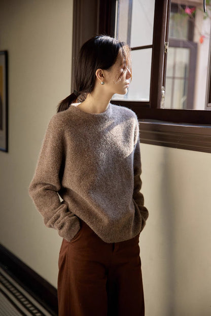 Coffee brown brushed wool sweater in side view by window showcasing soft drape and oversized silhouette