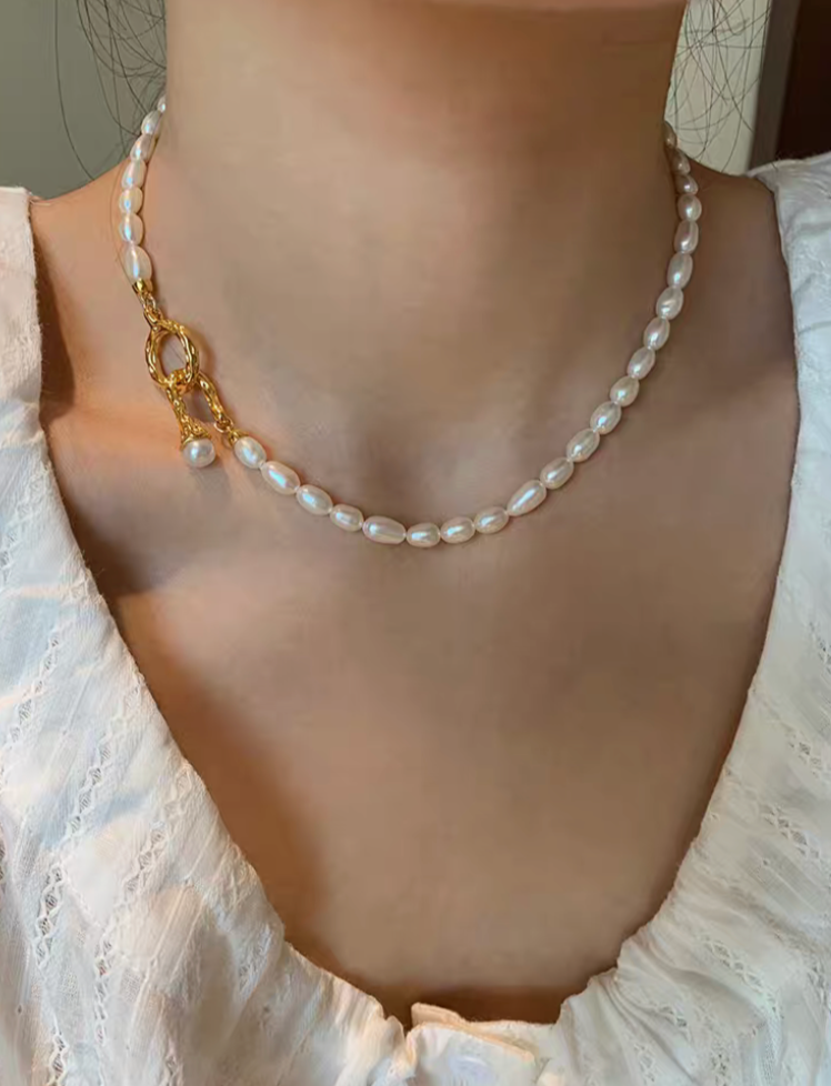 Freshwater pearl choker necklace worn on neck, featuring small natural pearls and gold clasp for elegant minimalist style