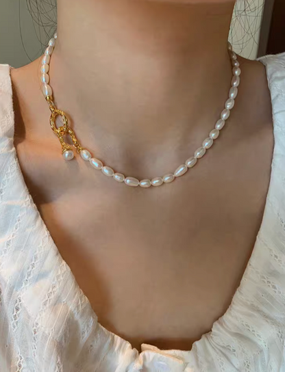Freshwater pearl choker necklace worn on neck, featuring small natural pearls and gold clasp for elegant minimalist style