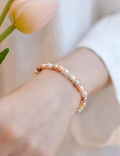 Close-up wrist shot of white with pinkish purple freshwater pearl bracelet highlighting natural color variation.