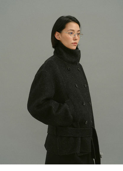 Side view of charcoal funnel-collar coat buttoned to the chin with belt
