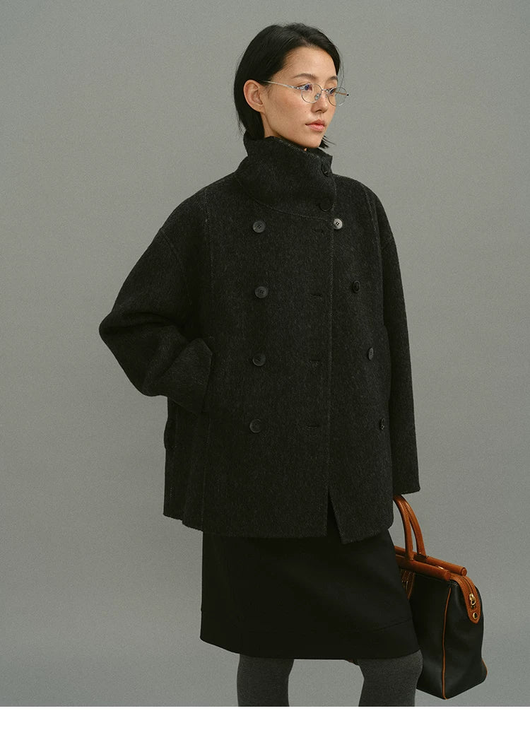 Charcoal double-breasted wool coat worn without belt, showing straight H-line cut