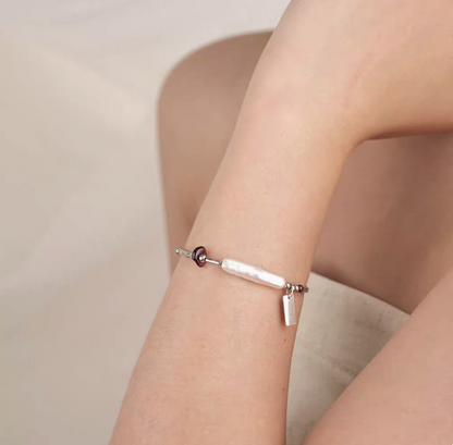 Garnet baroque pearl bracelet on wrist featuring natural freshwater pearl with silver chain and deep red garnet accent