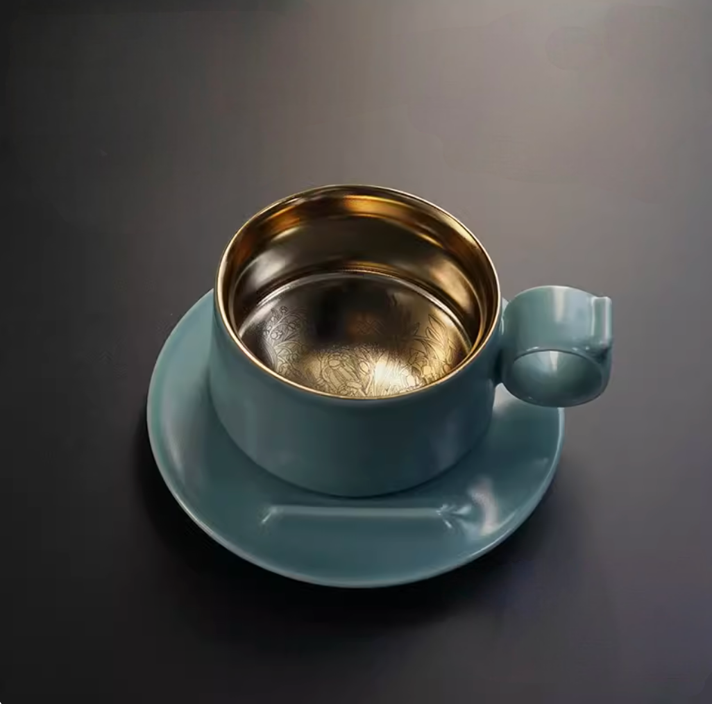 Sky Blue Gold titanium ceramic coffee mug with saucer, front view showing ring handle and gold interior with Lily of the Valley engraving