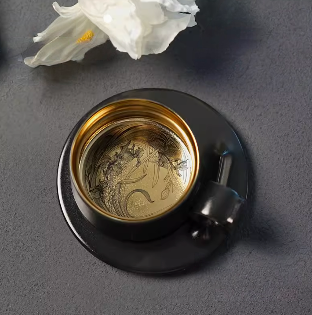 Starry Black Gold titanium ceramic coffee mug with saucer, top view showing gold interior with Iris flower engraving detail
