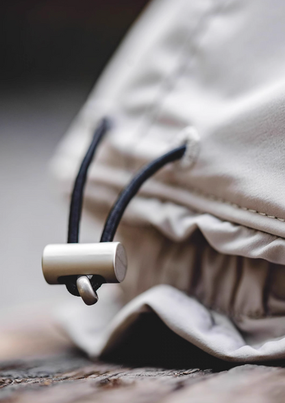 Close up of Glacier Guard Fleece Cap mountain rock gray and white showing adjustable drawcord at back secure fit system and durable polyester fabric