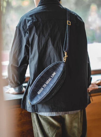 Back view of Goal-Line Denim Sling Crossbody Bag denim blue worn crossbody highlighting adjustable strap comfortable fit and clean minimal sporty aesthetic