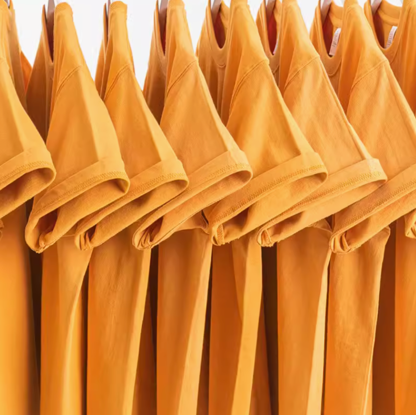 Golden Glow Tee mustard yellow color multiple shirts hanging on rack showing sleeve and fit