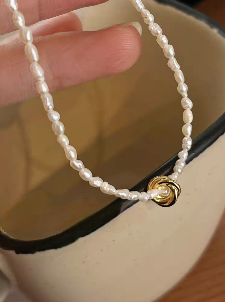 Close-up of Golden Knot Freshwater Pearl Necklace highlighting gold knot centerpiece and small pearl design