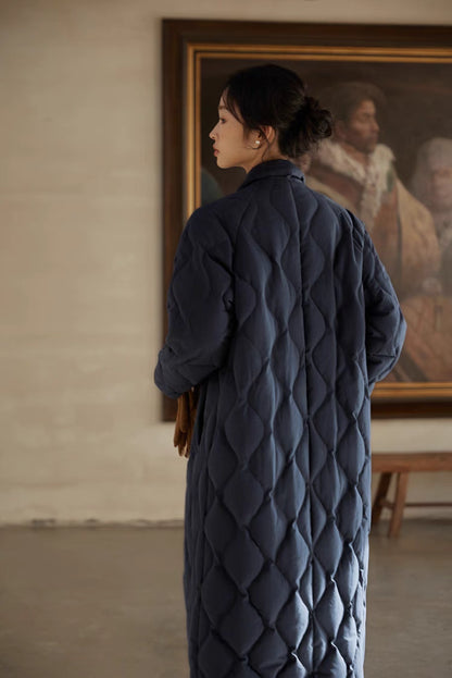 Back view of navy blue quilted longline coat featuring gourd stitch pattern, clean structure, and full-length design