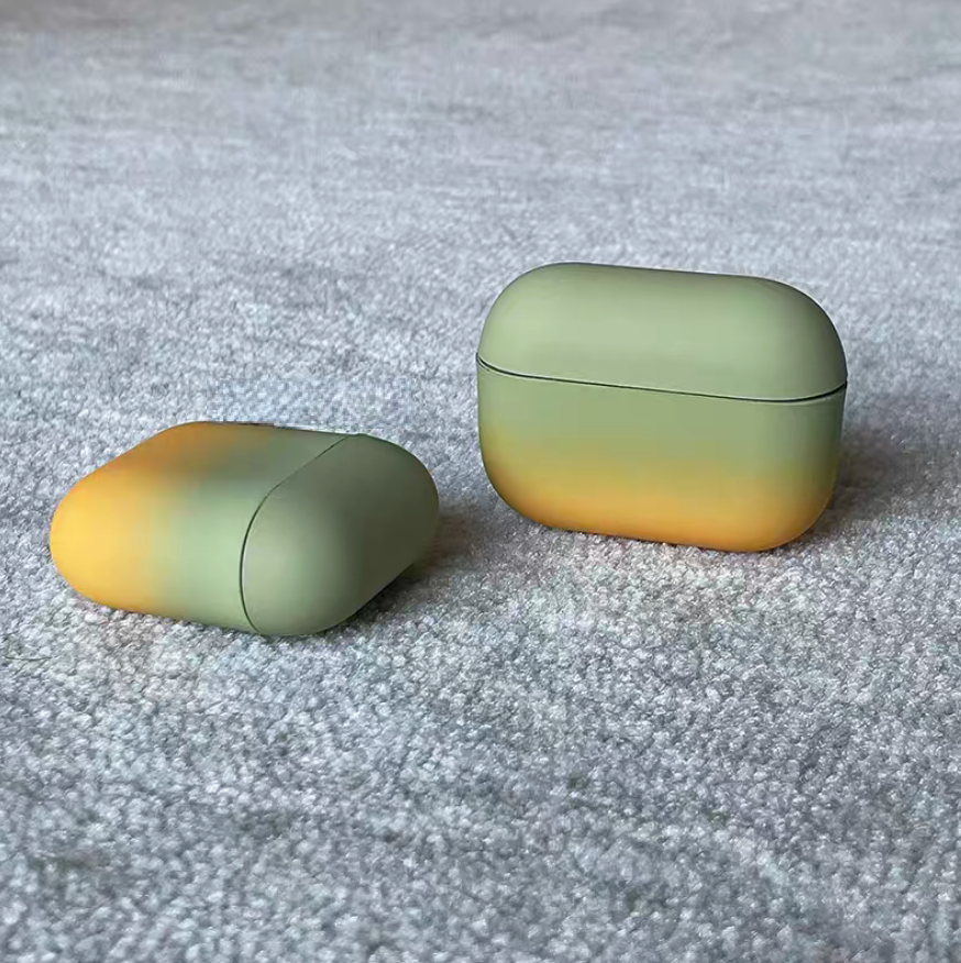 Avocado green to yellow gradient AirPods case showing closed case and separate top cover piece on soft fabric surface