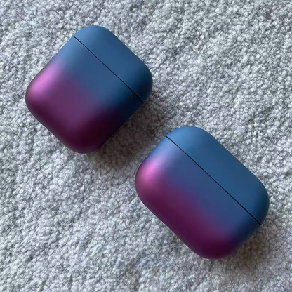 Two peacock blue to purple gradient AirPods cases placed diagonally showcasing color transition and soft matte texture