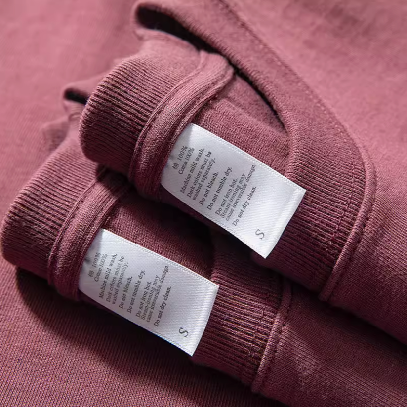 Grape Glow Tee Burgundy fabric care label close-up showing cotton material and stitching detail