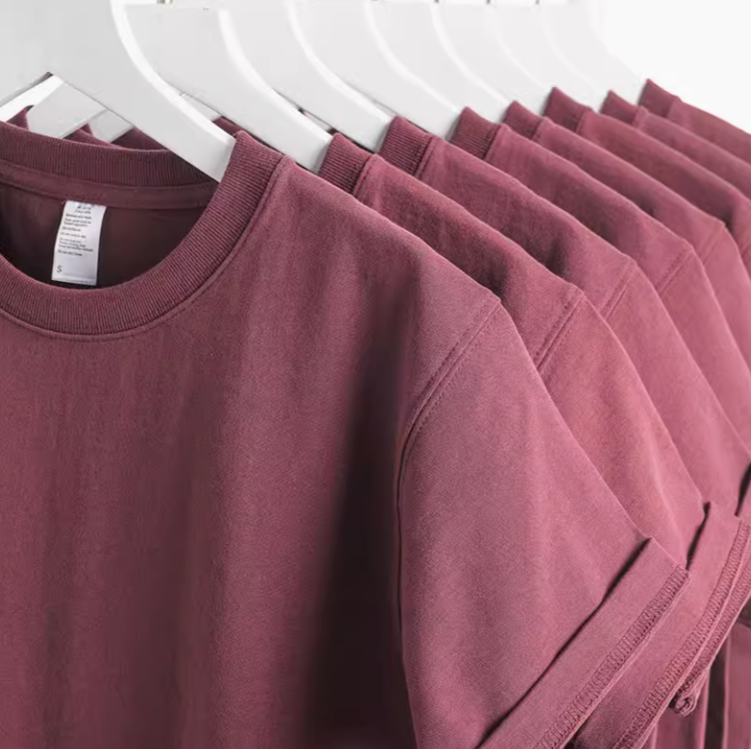 Grape Glow Tee Burgundy multiple shirts hanging on rack showing consistent color and fit