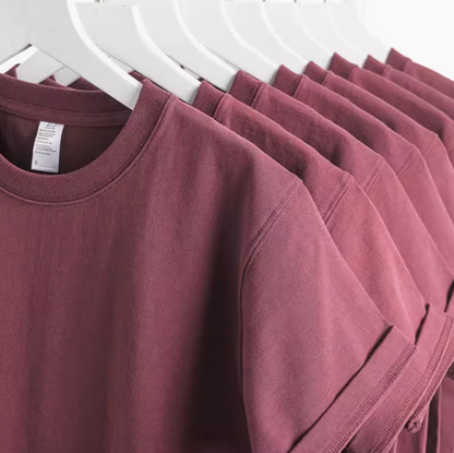 Grape Glow Tee Burgundy multiple shirts hanging on rack showing consistent color and fit