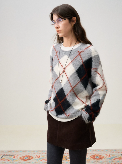 Three-quarter view of a Gray Argyle oversized sweater worn with ribbed cuffs pushed up