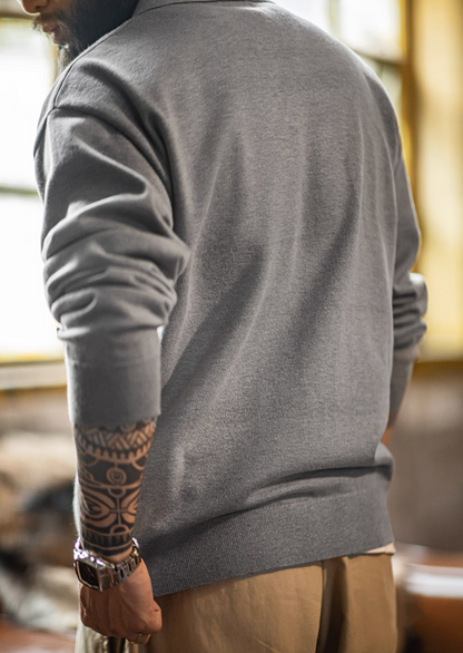 Back view showing smooth drape and ribbed hem of gray knit polo sweater.