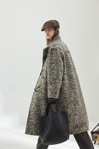Side view of a Gray Marl long bouclé coat in motion, showing the toggles and dropped shoulders