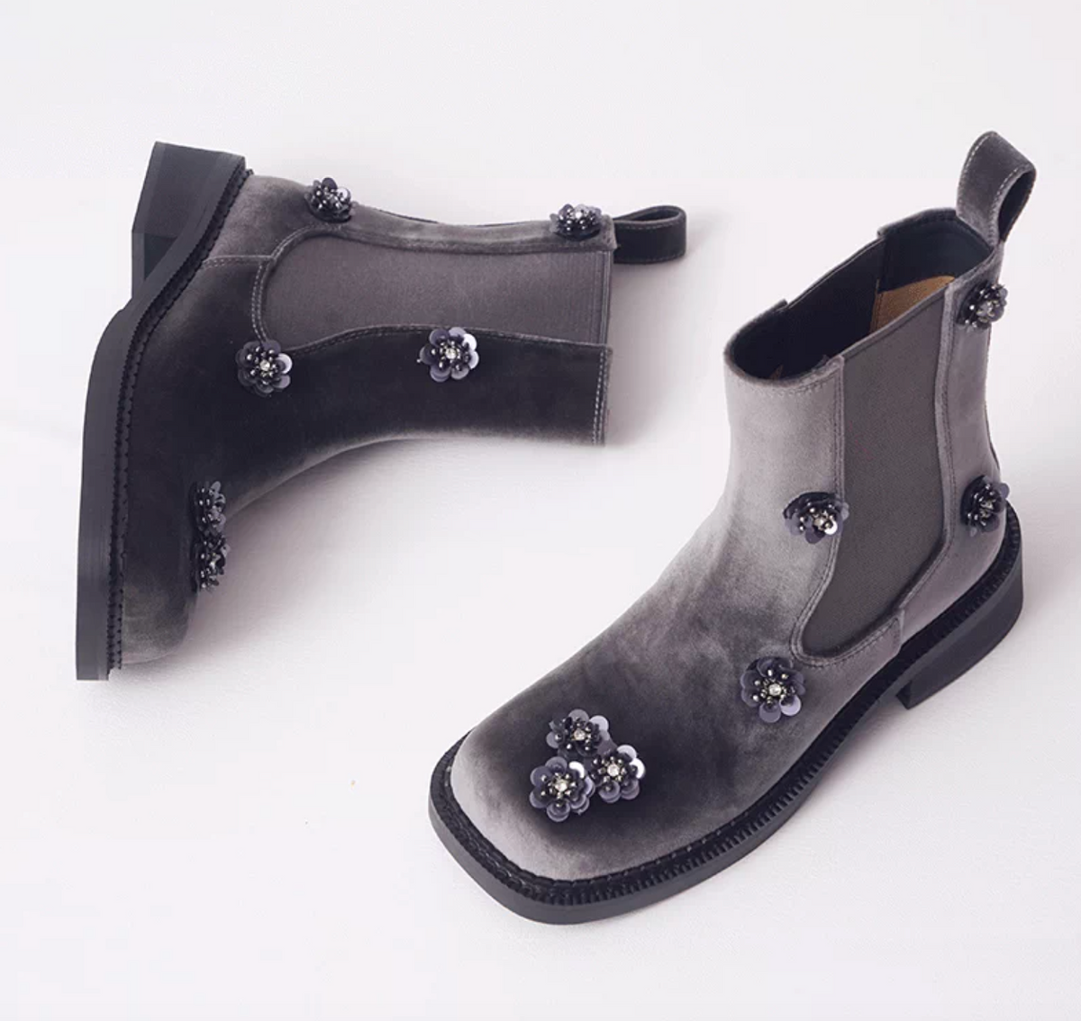 Top view of gray velvet Chelsea boots with black sequin flowers and a square toe