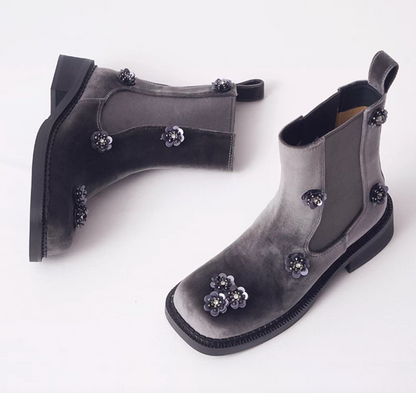 Top view of gray velvet Chelsea boots with black sequin flowers and a square toe