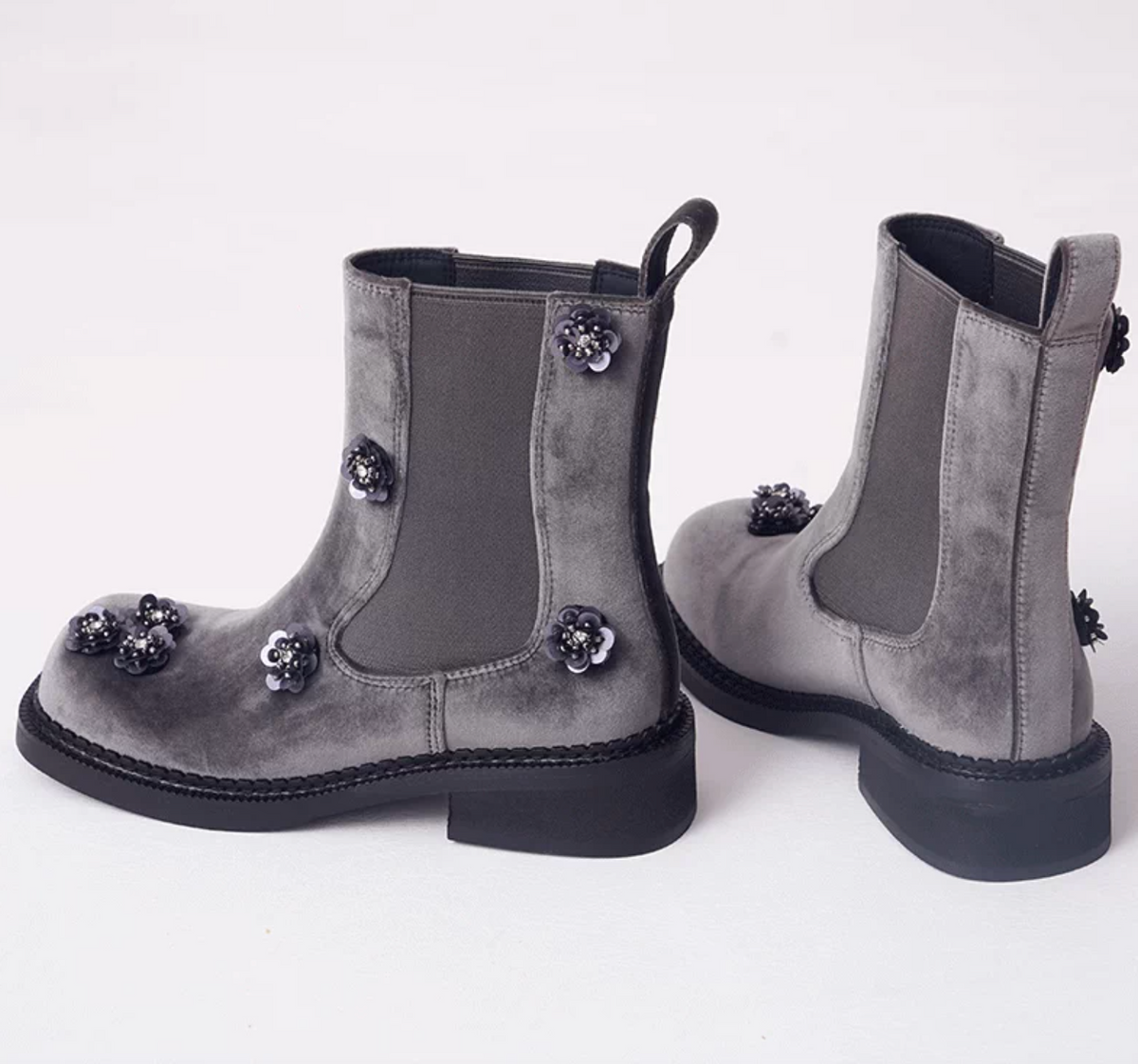 Side view of gray velvet Chelsea boots showing the elastic side panel and block heel