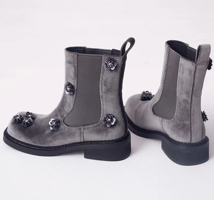 Side view of gray velvet Chelsea boots showing the elastic side panel and block heel