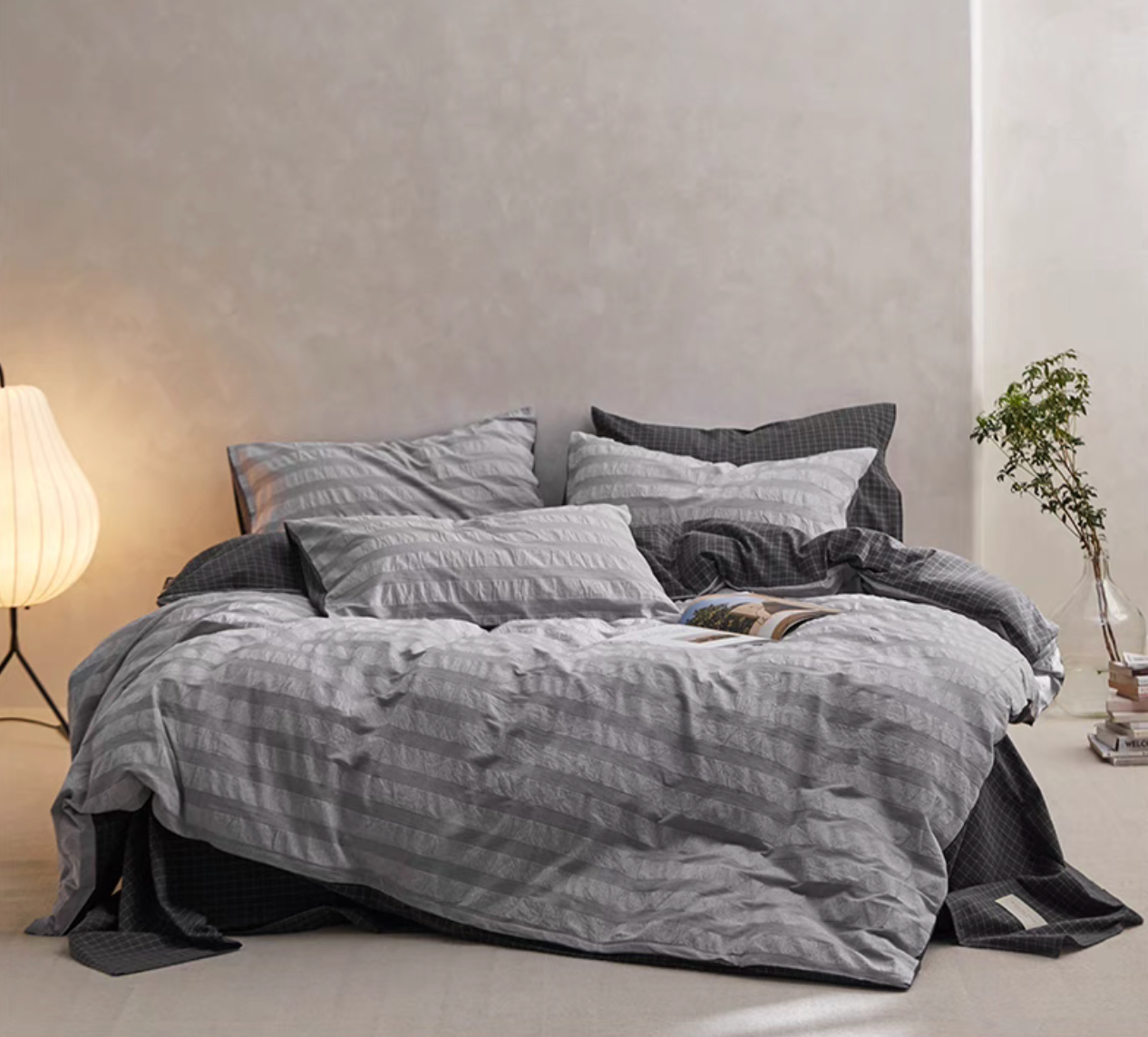 Gray Grid cotton duvet, sheet and shams set with textured stripe duvet cover layered over dark checked bedding