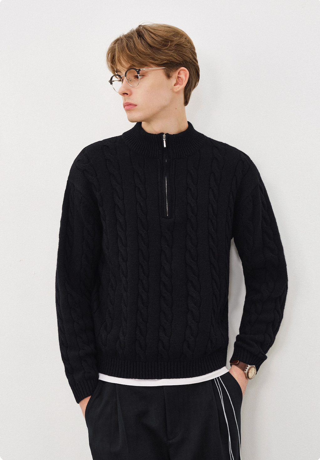 Men’s black half-zip cable knit sweater with mock neck styled casually.