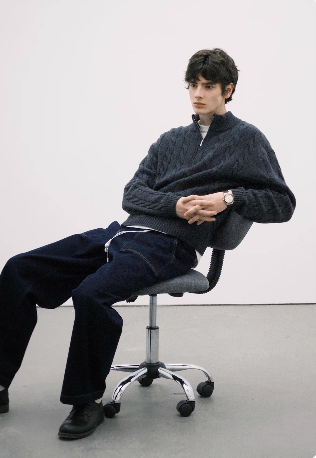 Charcoal half-zip cable knit sweater styled for casual winter look.