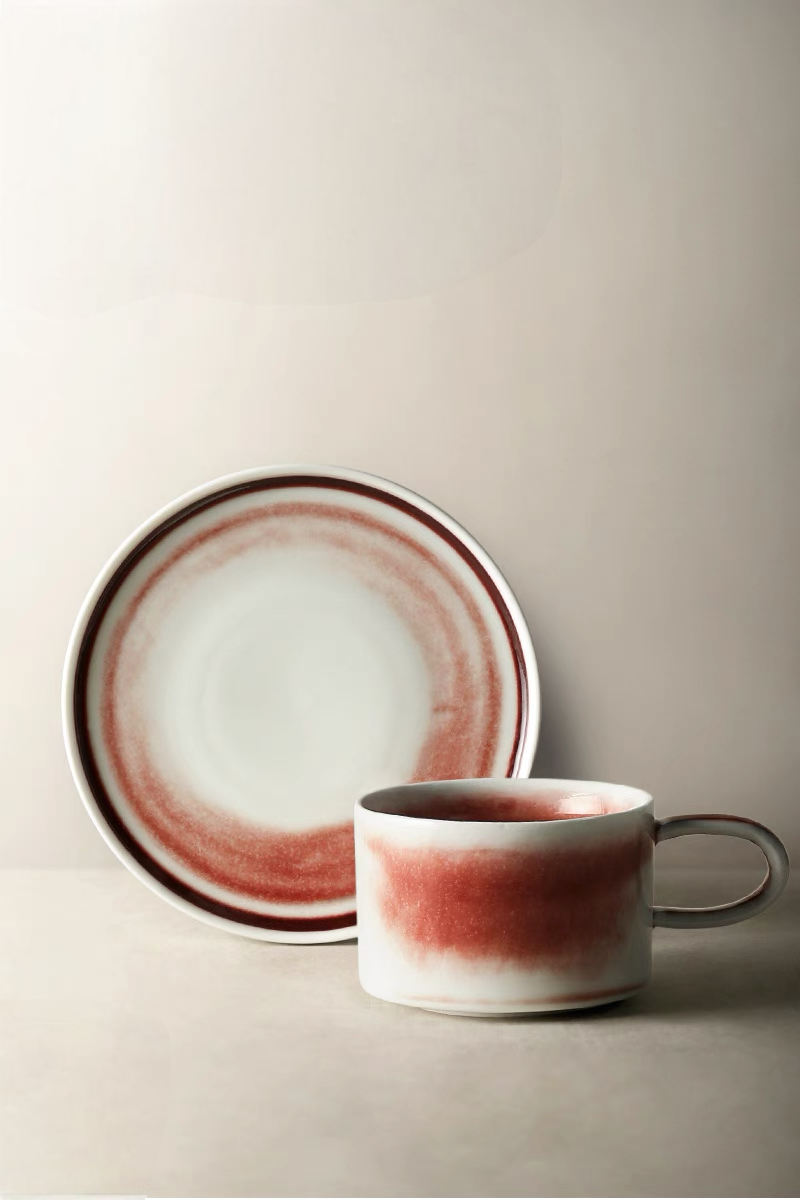 Style 1 handcrafted crimson glaze ceramic cup and saucer front view with soft beige base and red gradient ring pattern