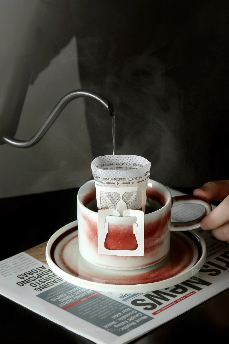Style 1 handcrafted ceramic cup with pour-over coffee filter showcasing practical use and rich crimson glaze detail