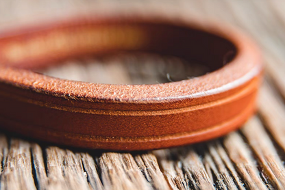 Dark brown handcrafted leather loop bracelet close-up showing smooth oil-finished leather surface and edge detail