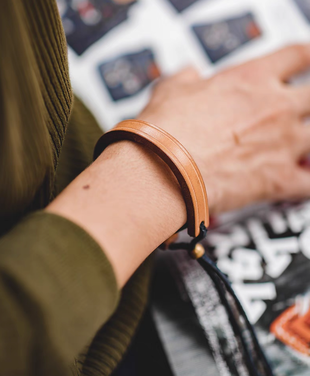 Original color handcrafted leather loop bracelet worn on wrist close-up showing minimalist leather band and adjustable cord