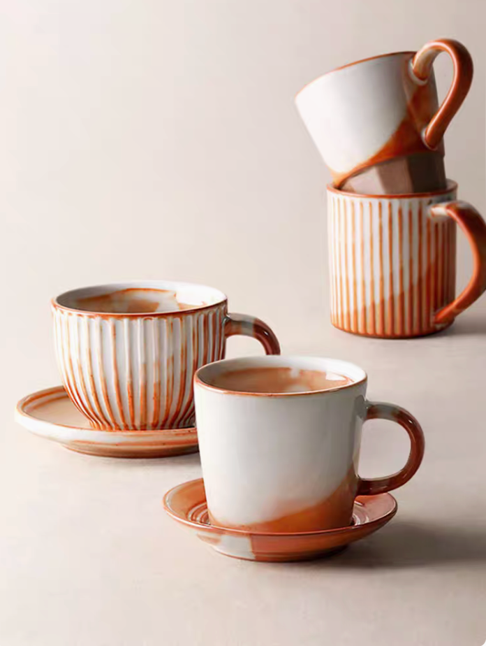 Handcrafted Vintage Ceramic Mug collection in off-white and orange showing multiple styles arranged together with cup and saucer set