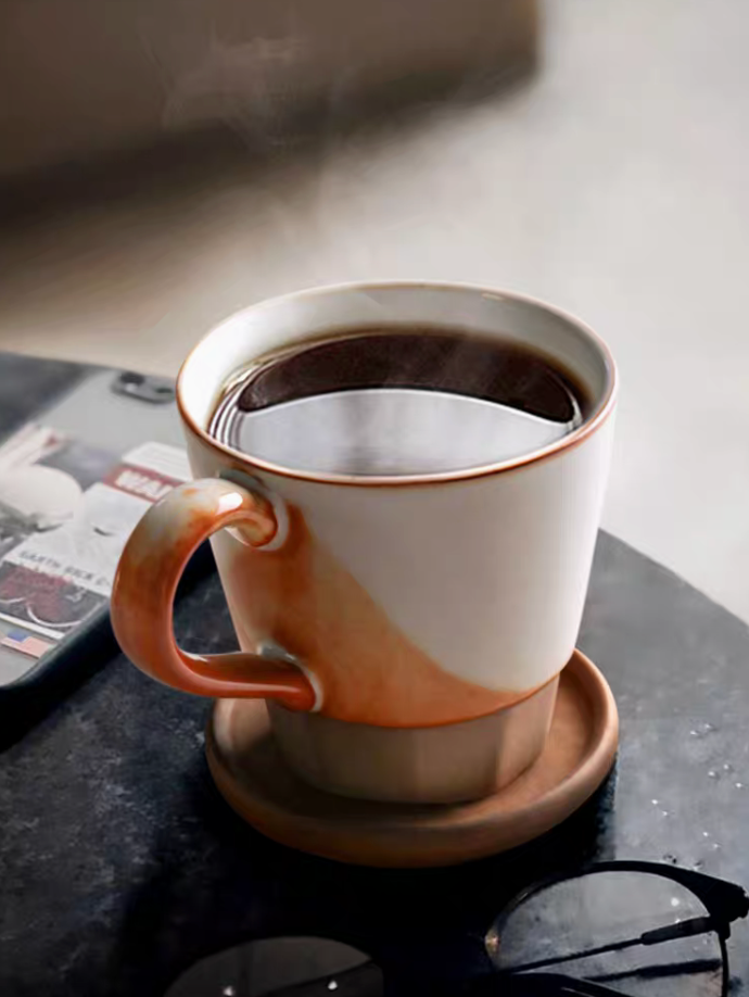 Style 1 handcrafted vintage ceramic cup and saucer set in off-white and orange filled with coffee in close-up lifestyle scene