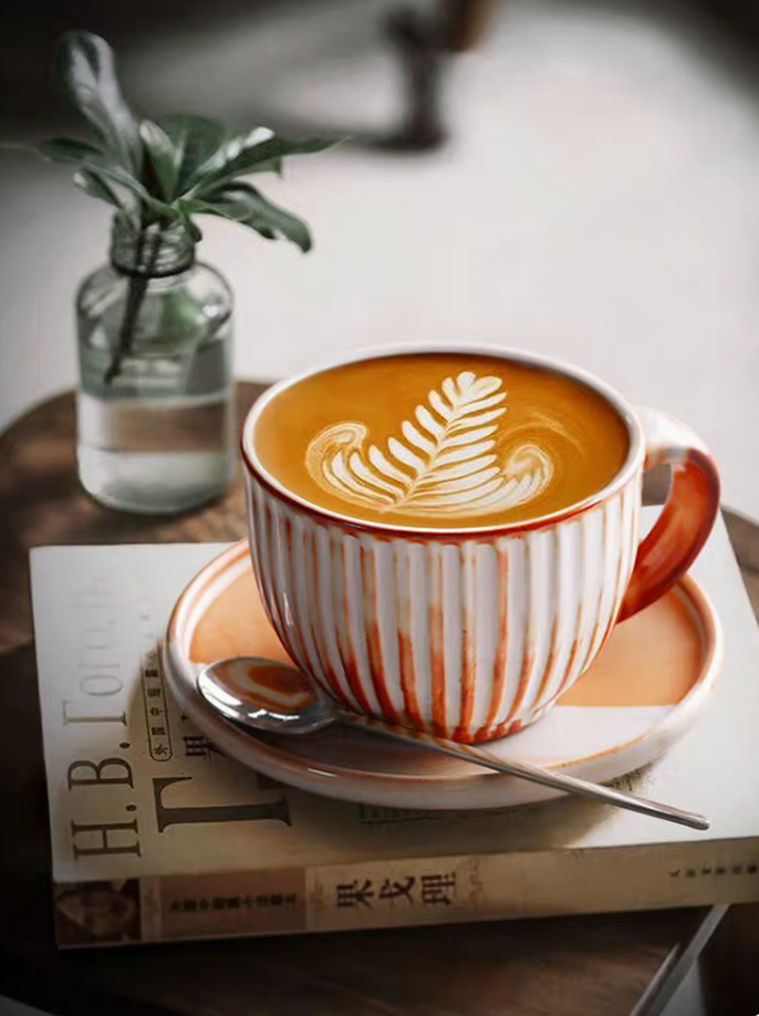 Style 2 handcrafted ridged ceramic cup and saucer in off-white and orange shown in clean minimal product view