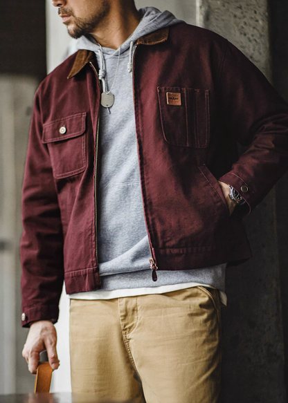 Model wearing the burgundy Hardman Detroit 90s Workwear Jacket layered over a hoodie, styled with beige pants.