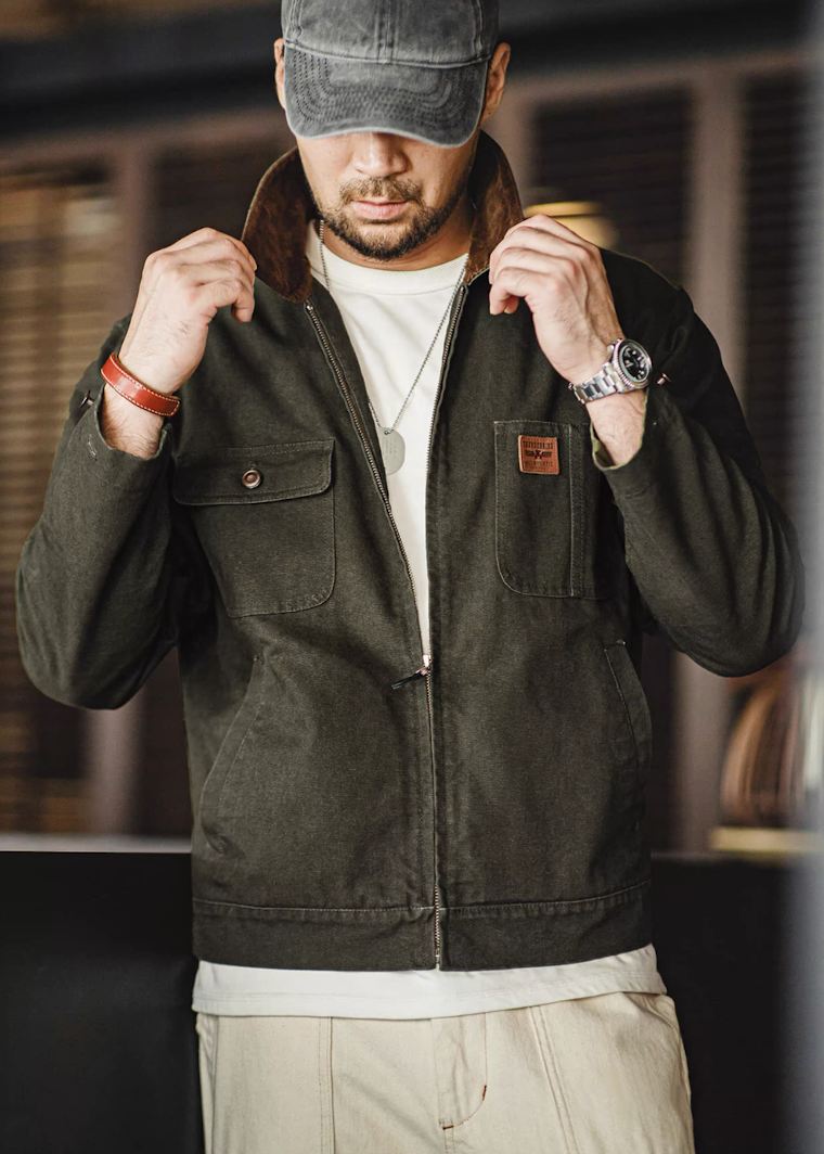 Model adjusting the collar of the green Hardman Detroit 90s Workwear Jacket, showcasing a rugged style.