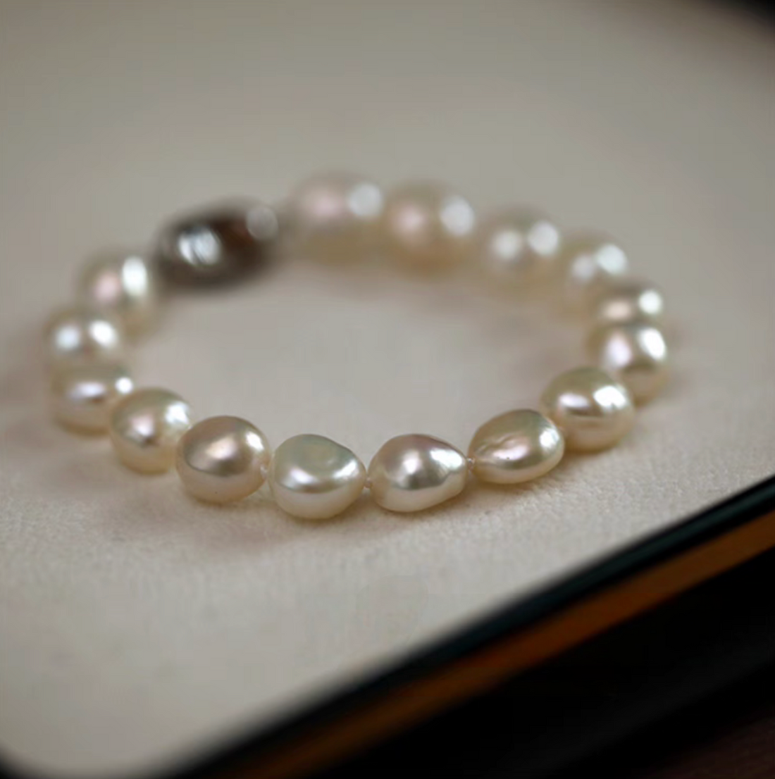 Heavy baroque freshwater pearl bracelet with irregular natural pearls arranged in a continuous loop, close-up soft lighting