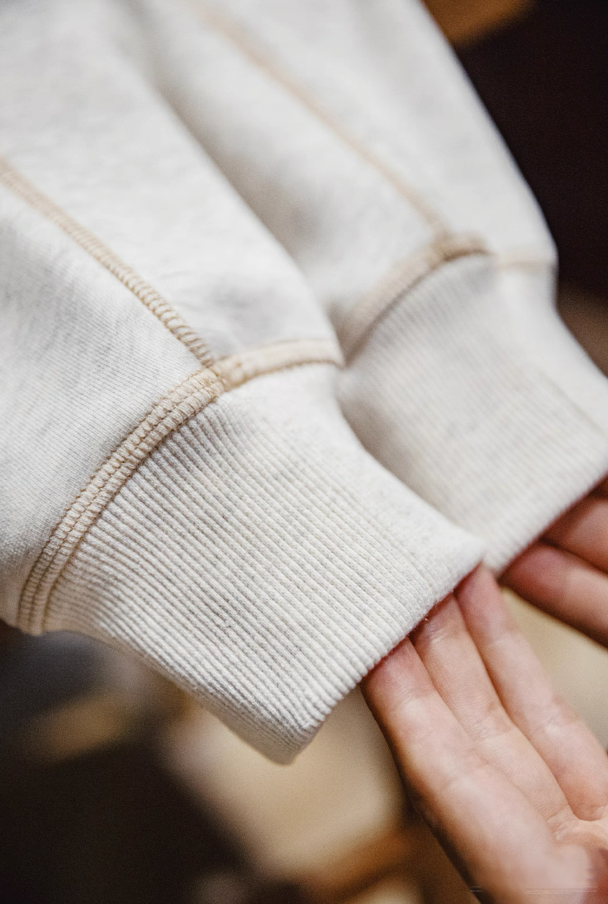 Close-up of ribbed sleeve cuff and stitching texture of sweatshirt.