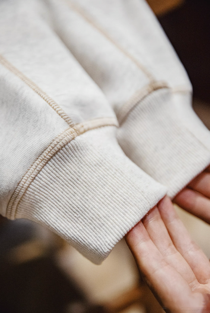 Close-up of ribbed sleeve cuff and stitching texture of sweatshirt.