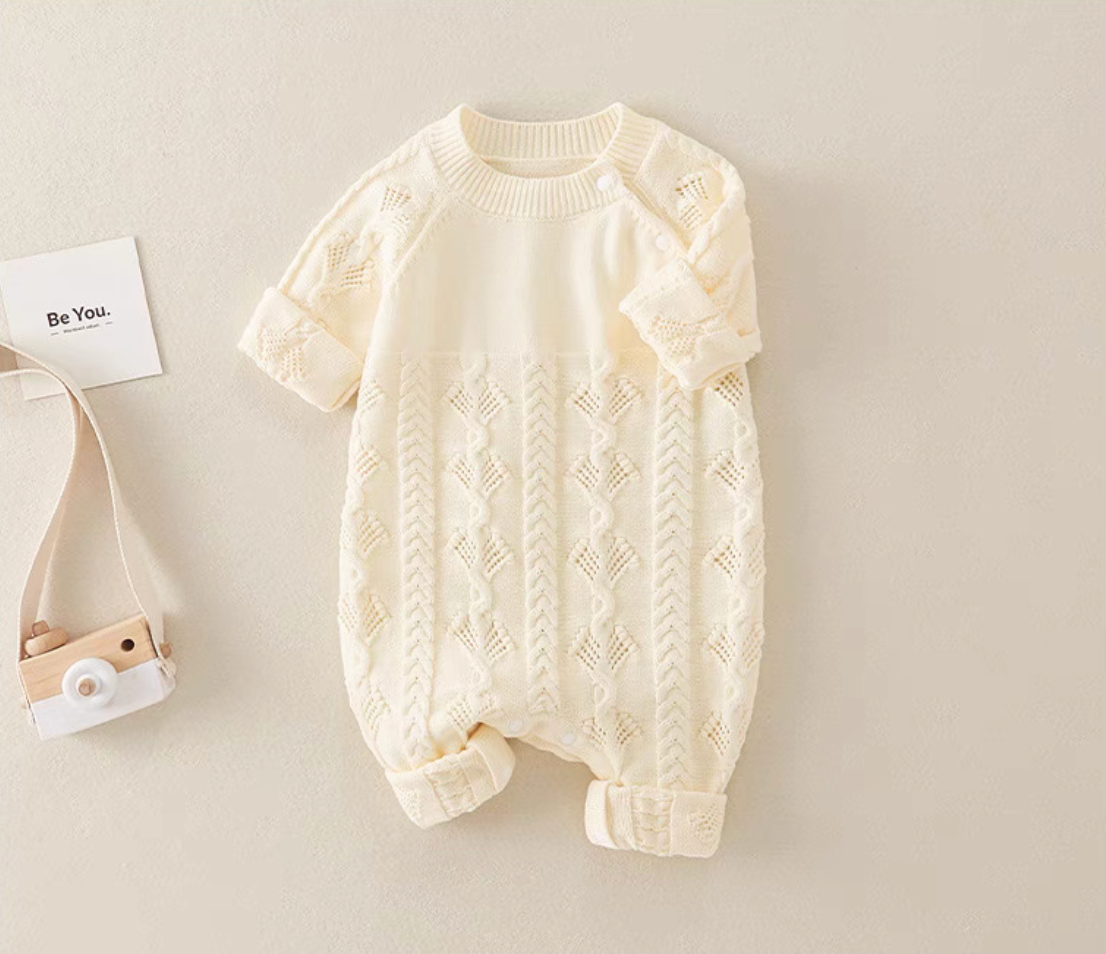 Beige cotton cable knit baby romper front view with lace knit pattern and ribbed cuffs