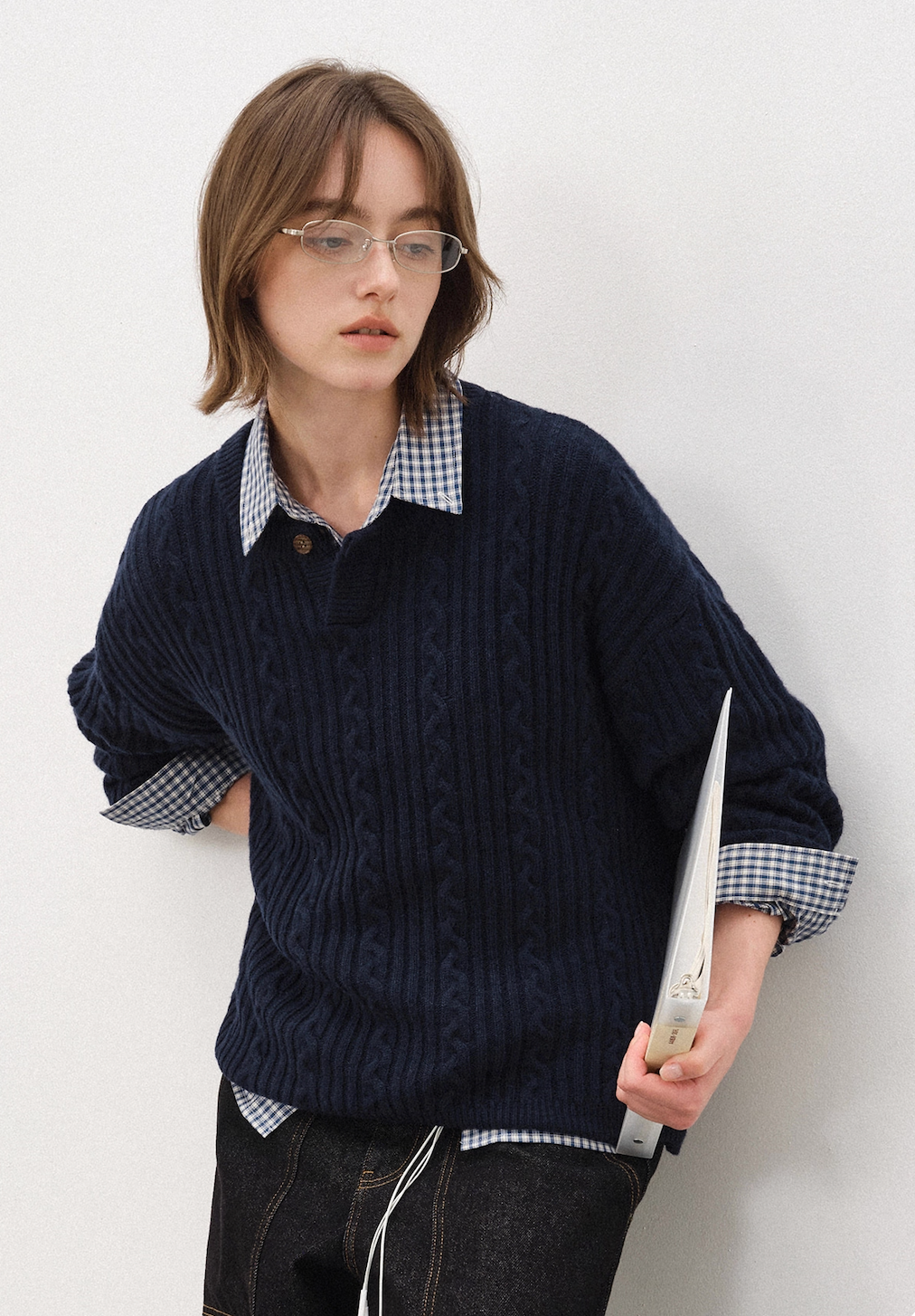 Full-body styling of navy wool blend Henley cable-knit sweater on female model