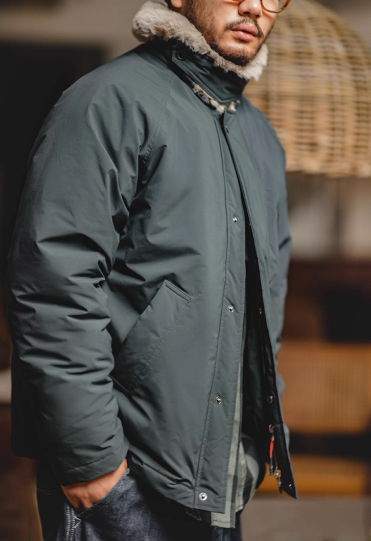 Side view of man wearing slate blue faux-fur collar bomber jacket.
